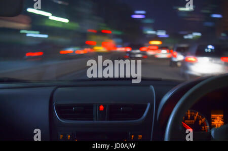 Light trails of vehicles traffic in the night. The shot was taken from inside of a car using low speed shutter photography effect. Stock Photo