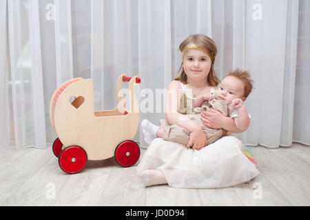 little girld holds her younger brother Stock Photo