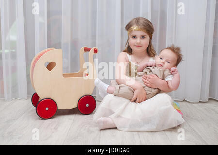 little girld holds her younger brother Stock Photo