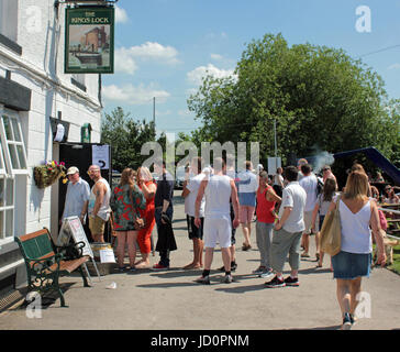 Middlewich, Cheshire, UK. 17th June, 2017. Cw 3084 Queue for beer outside the Kings Lock pub at Middlewich FAB 2017 Over the weekend on June the 17th and 18th of June 2017 it is the Middlewich Folk and Boat festival at Middlewich in Cheshire. On Saturday the sun blazed down, it was warm and there were lots of folks out enjoying the festival. The pubs where doing a fantastic trade in selling beer and refreshments to the festival goer's with people forming orderly queues as here at the Kings Lock pub. Credit: Colin Wareing/Alamy Live News Stock Photo