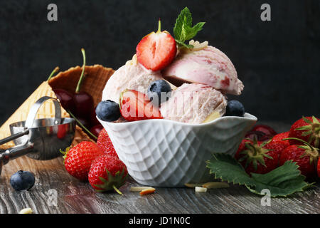 Strawberry ice cream in white bowl with fresh strawberries and mint Stock Photo