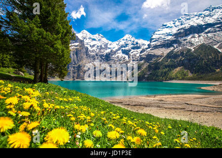 Amazing tourquise Oeschinnensee with waterfalls, wooden chalet and Swiss Alps, Berner Oberland, Switzerland.