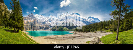 Amazing tourquise Oeschinnensee with waterfalls, wooden chalet and Swiss Alps, Berner Oberland, Switzerland.