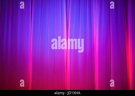 Bright pink and purple stage curtain with spotlight. Abstract background. Stock Photo