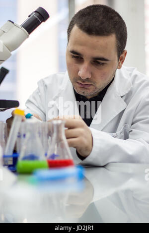 Young doctor performs tests and lab wearing a white coat Stock Photo