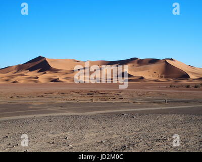 ERG CHEBBI dunes range near MERZOUGA city with landscape of sandy desert formations in southeastern MOROCCO near border with ALGIERIA, clear blue sky. Stock Photo
