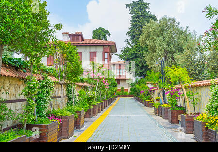 The daily walk along the street of Kaleici neighborhood, the small trees, blooming shrubs and flowers in tubs decorate the way along the old Ottoman h Stock Photo