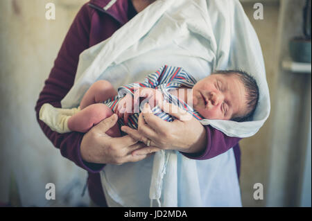 A senior woman is holding a newborn baby Stock Photo