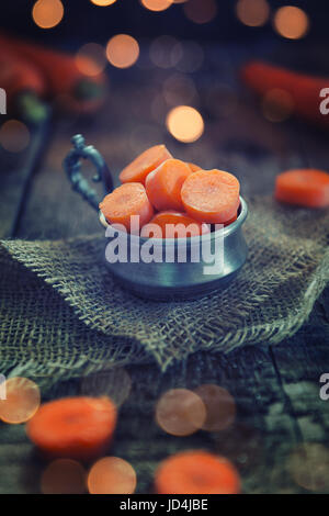 Sliced carrots on dark wood table background Stock Photo