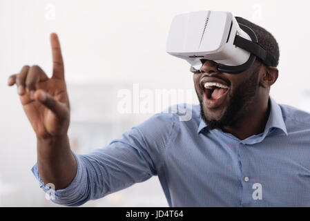 Delighted happy man using innovative technologies Stock Photo