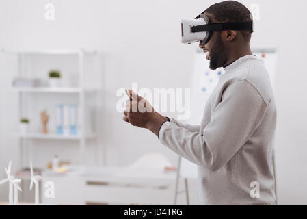 Nice pleasant man using virtual reality glasses Stock Photo