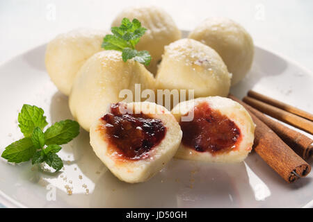 Traditional austrian, czech and hungarian sweet dumplings called Knödels filled with plum and spiced with cinnamon were prepared in boiled water and s Stock Photo