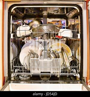 Dirty dishes loaded in a dishwasher. Stock Photo