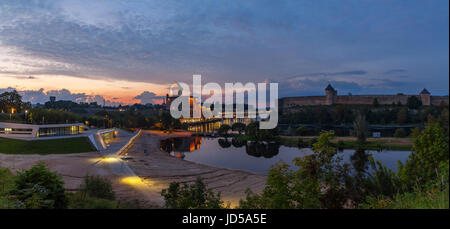 Opposition of two medieval fortresses on the river Narva at sunset, Estonia and Russia border. Wide panoramic view Stock Photo