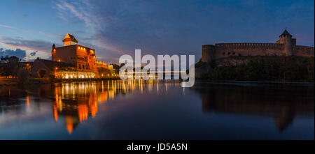 Opposition of two medieval fortresses on the river Narva at blue hour, Estonia and Russia border. Wide panoramic view Stock Photo