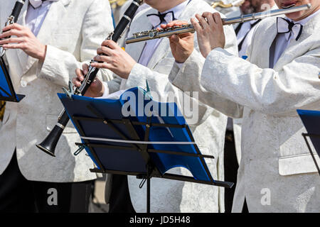 hands of musicians playing flute and clarinets during street concert Stock Photo