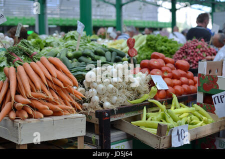 Different sorts of vegetables - onion, tomatoes, carrots - on a green market stall Stock Photo