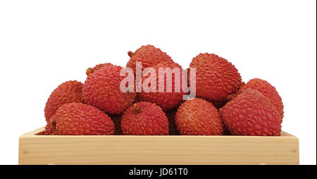 Heap of fresh picked red ripe litchee (Litchi chinensis) tropical fruits in wooden container box isolated on white background, close up, low angle sid Stock Photo