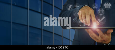 Banner - concept of modern digital management - businessman holds in his hand a digital tablet and manages the various divisions of the corporation th Stock Photo