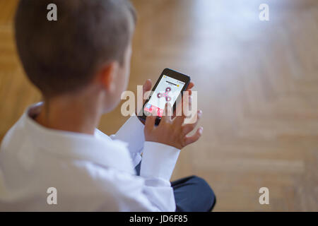 Little boy playing on smartphone spinner app Stock Photo