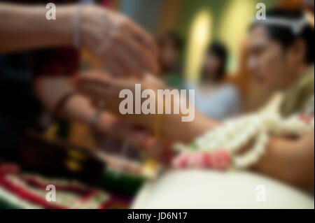 Close-up of holy water being poured on the hands of the bride from elders during a traditional Thai wedding ceremony, Thailand Stock Photo