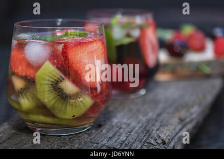 Glasses fruit water with various ingredients presented on a tree disk Stock Photo