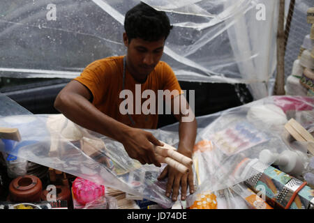 Dhaka, Bangladesh. 18th June, 2017. A street vendor is fixing plastic polyethylene during rain in the outcast of Dhaka. Credit: Md. Mehedi Hasan/ZUMA Wire/Alamy Live News Stock Photo