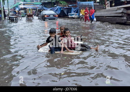 Dhaka, Bangladesh. 19th Jun, 2017. Bangladeshi children row a makeshift raft on a flooded road in Dhaka, Bangladesh, June 19, 2017. Encroachment of canals is contributing to the continual water logging in the Capital Dhaka. Credit: SK Hasan Ali/Alamy Live News Stock Photo