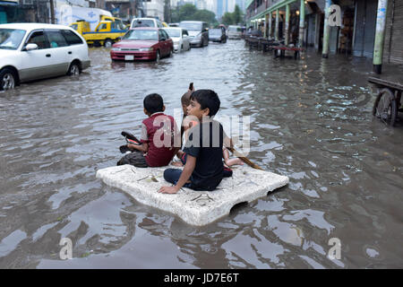 Dhaka, Bangladesh. 19th Jun, 2017. Bangladeshi children row a makeshift raft on a flooded road in Dhaka, Bangladesh, June 19, 2017. Encroachment of canals is contributing to the continual water logging in the Capital Dhaka. Credit: SK Hasan Ali/Alamy Live News Stock Photo