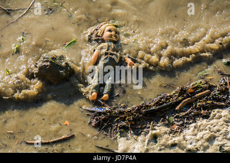 A child's doll floating forlornly in the River Thames, London, UK Stock Photo