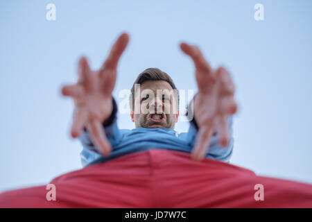 Caucasian man stretching hands down. Threaten and snap someone. Stock Photo