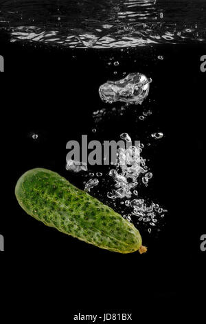 Cucumber in water with splashes on a black background,water splash Stock Photo