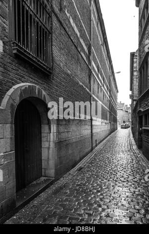 View along narrow street of buildings and cobbles, black and white, Belgium. tournai old town belgium europe Stock Photo