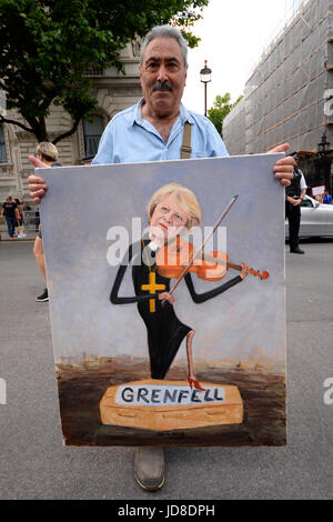 Kaya Mar artist. Theresa May playing over Grenfell victim coffin. Anti Tory DUP alliance demonstration outside Downing Street in Whitehall, London Stock Photo