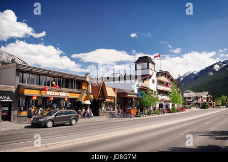 Street scenery of McDonald's and other shops and restaurants on Banff Avenue, downtown of Banff in Alberta Rockies with Rocky Mountains in the backgro Stock Photo