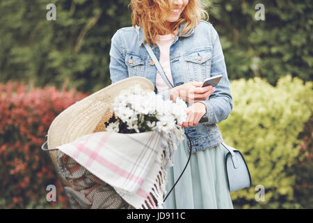 Using mobile phone by urban female cyclist Stock Photo