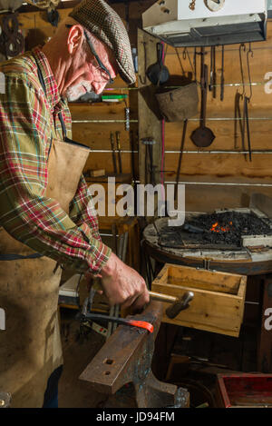 Blacksmith Hammering and Shaping Steel On Anvil Stock Photo