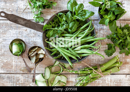 Homegrown vegetables and herbs in a colander on a vintage wooden table Stock Photo