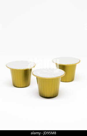 Three isolated Yellow coffee pods on white background Stock Photo