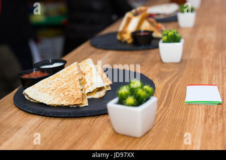 Beautiful tasty appetizing traditional mexican food quesadilla with meat and vegetables on black slate Stock Photo