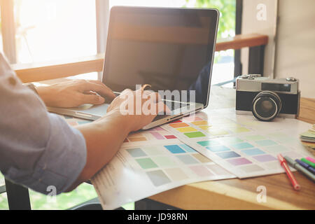 Graphic design and color swatches and pens on a desk. Architectural drawing with work tools and accessories. Stock Photo