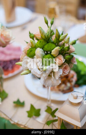 Beautiful wedding bouquet on a table of white and beige roses. Stock Photo