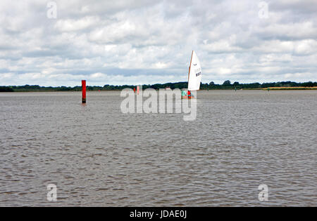 Two people sailing on Hickling Broad in a fair wind on the Norfolk Broads, England, United Kingdom. Stock Photo