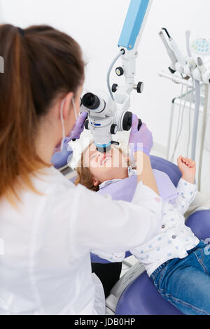 Woman examining girl with microscope Stock Photo