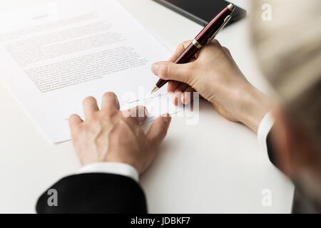 woman putting signature on business partnership contract Stock Photo