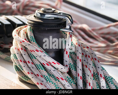 Self-tailing winch on sailing boat with coiled rope Stock Photo
