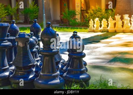 Big chess pieces on chessboard outside in holiday resort Stock Photo