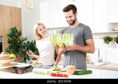 Married young couple enjoying their time at home while cooking in the kitchen Stock Photo