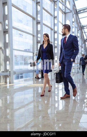 Business people walking in modern glass office corridor Stock Photo