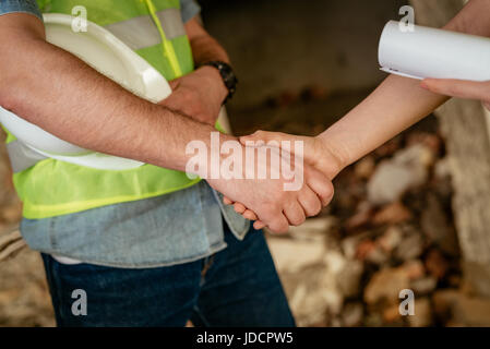 Close-up of a shaking hands of a construction workers in building damaged in the disaster. Stock Photo